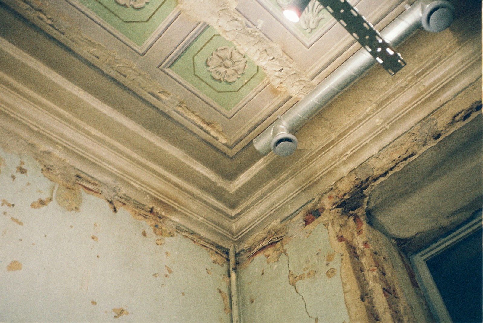 the ceiling of a run down room with peeling paint